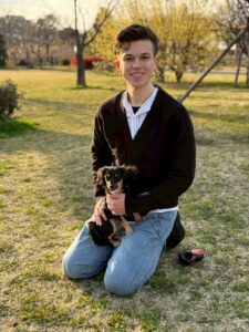 Biehl Kösep, responsable de éxito de clientes de PetAirJPN. Abrazar a un perro en el parque y abrazarlo con una sonrisa sincera.